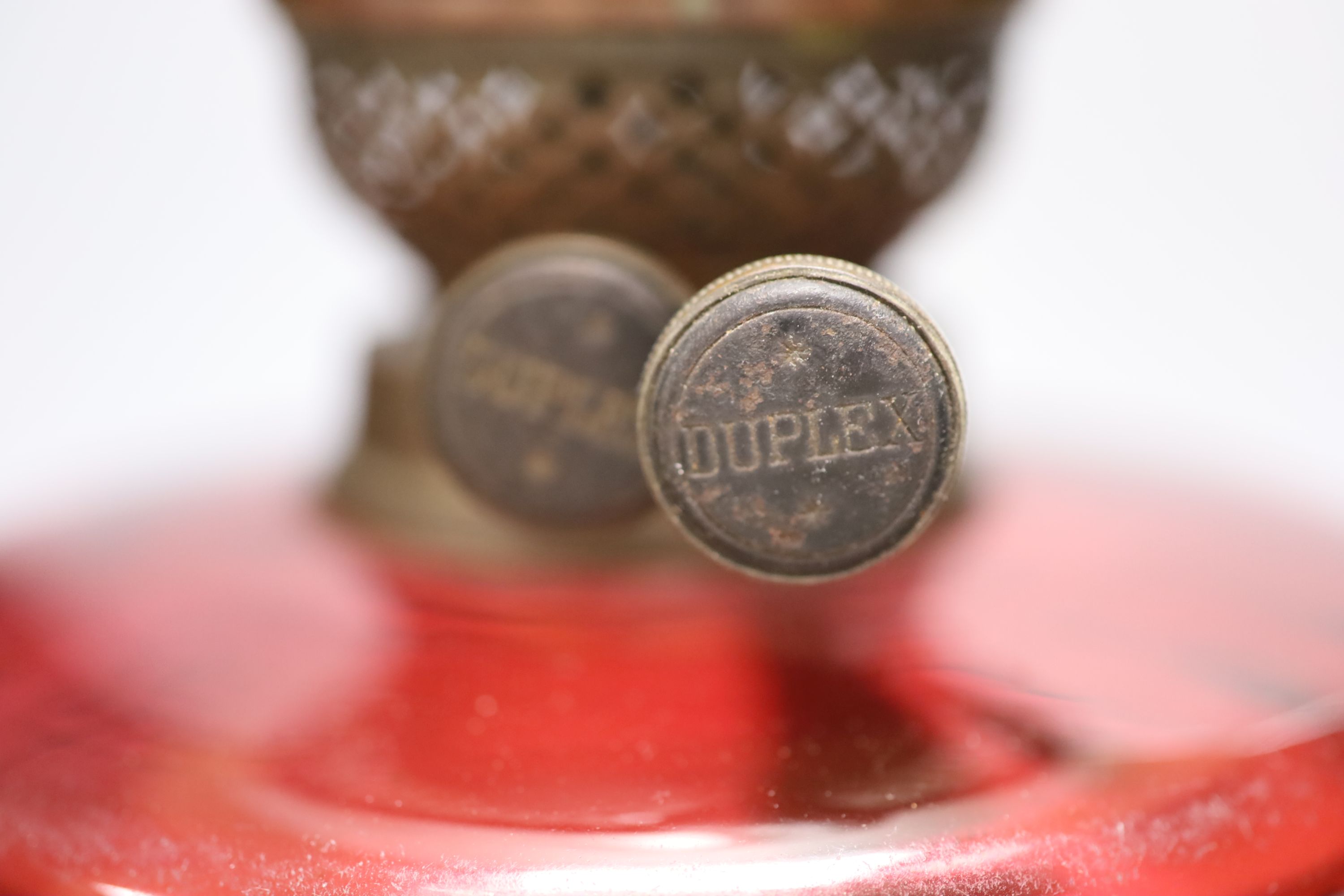 A 19th century oil lamp with a cranberry reservoir